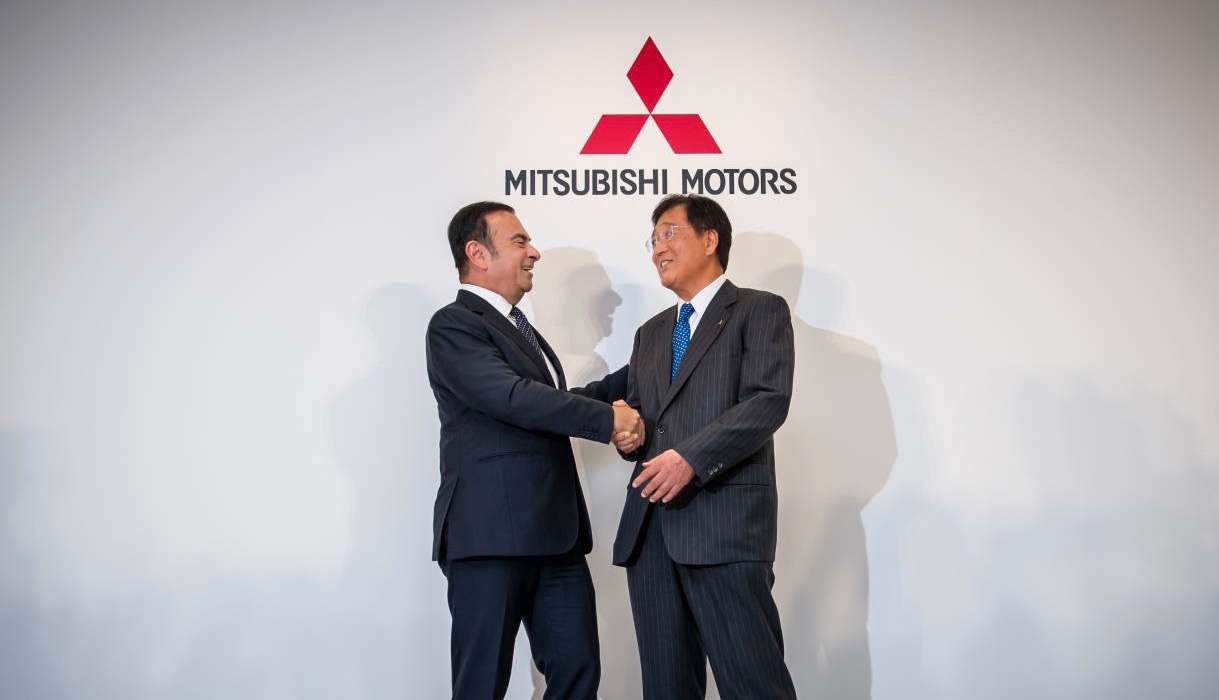Carlos Ghosn of Renault-Nissan shakes hands with Osamu Masuko of Mitsubishi.