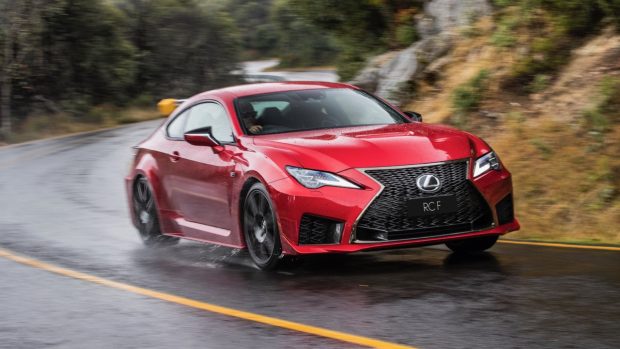 Panning image of a red 2020 Lexus RC F driving on a wet mountain road