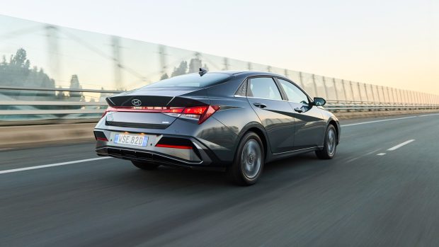 Hyundai i30 Sedan hybrid 2024 driving rear highway
