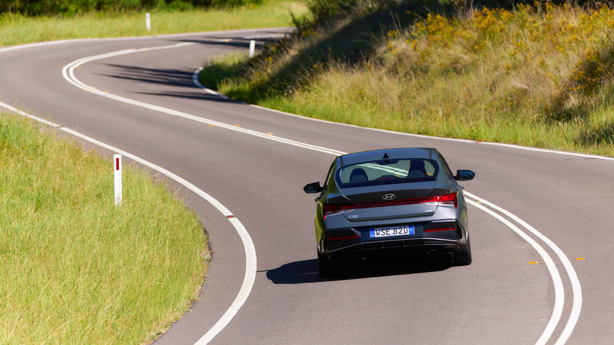 Hyundai i30 Sedan hybrid 2024 driving rear far