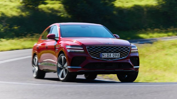 2025 Genesis GV80 Coupe red on avenue utilizing shot