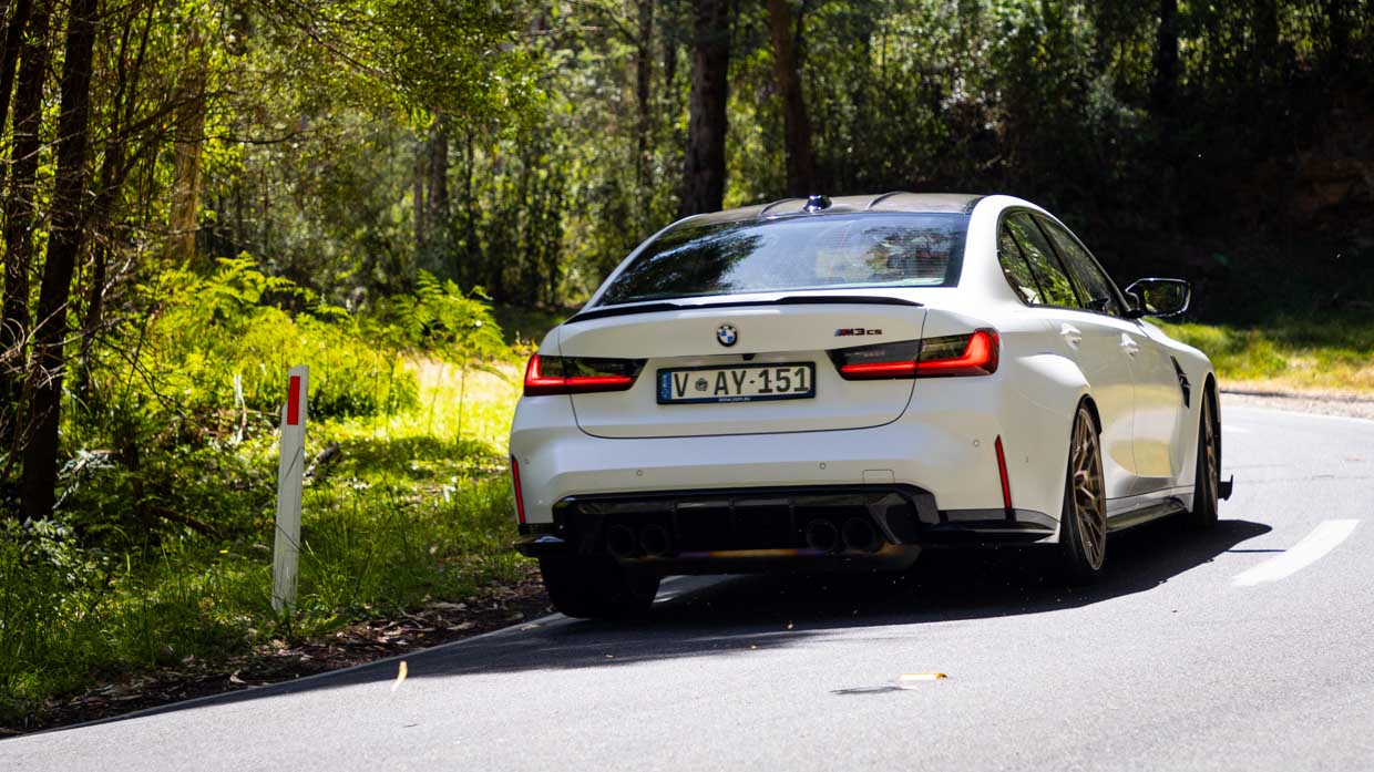 BMW M3 CS 2024 driving rear 3/4 3