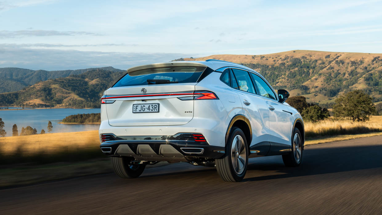 2024 MG HS white rear 3/4 driving shot countryside